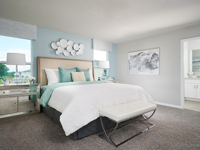 carpeted bedroom featuring ensuite bath and a textured ceiling