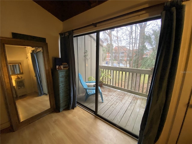 entryway with vaulted ceiling and light hardwood / wood-style flooring