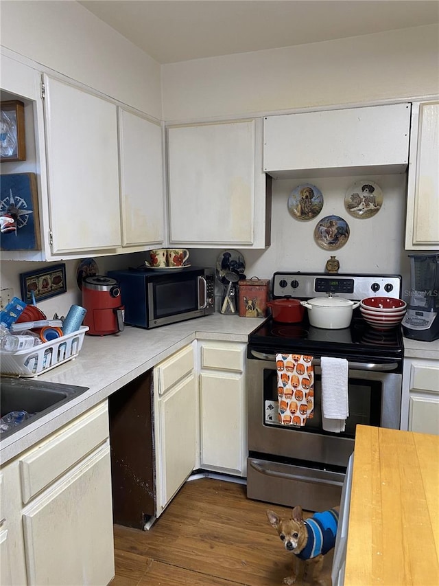 kitchen with stainless steel appliances, white cabinets, and dark hardwood / wood-style flooring