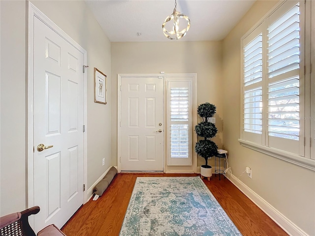 entryway featuring an inviting chandelier, dark hardwood / wood-style floors, and a wealth of natural light