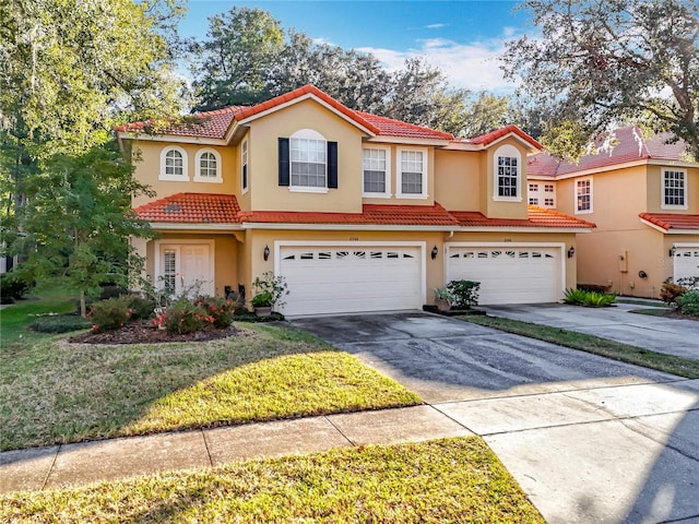 mediterranean / spanish-style house with a garage and a front lawn