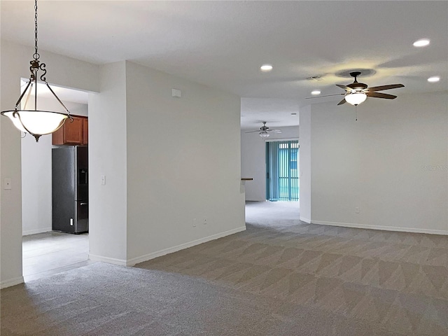 carpeted spare room featuring ceiling fan