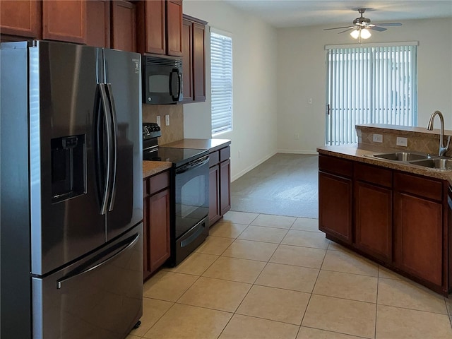 kitchen featuring sink, light tile patterned floors, ceiling fan, and black appliances