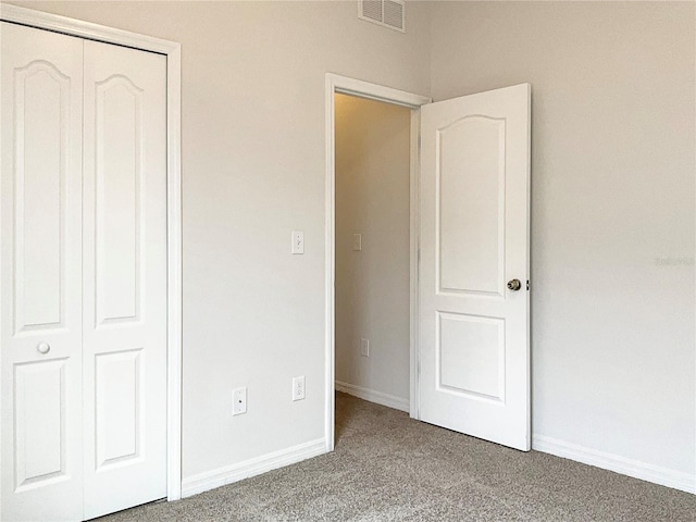 unfurnished bedroom with carpet floors and a closet