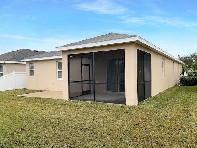 back of property featuring a patio, a sunroom, and a yard