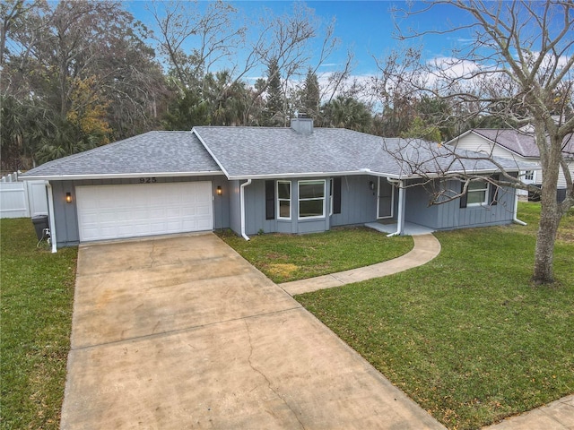 ranch-style house featuring a garage and a front lawn