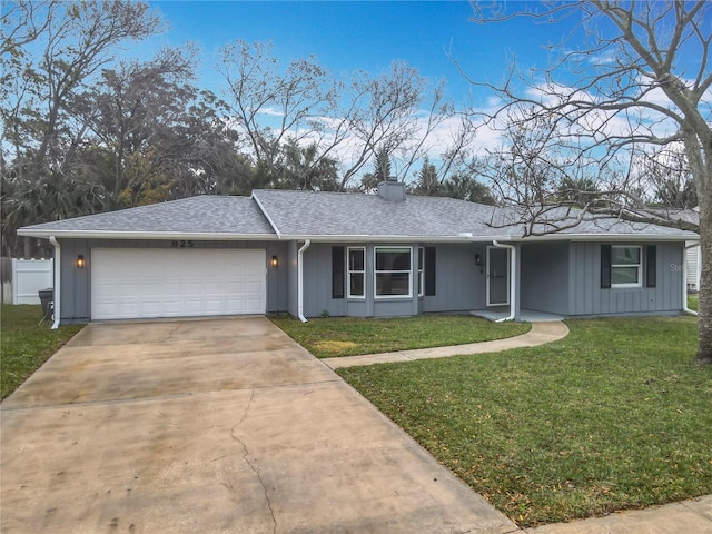 ranch-style home with a garage and a front lawn