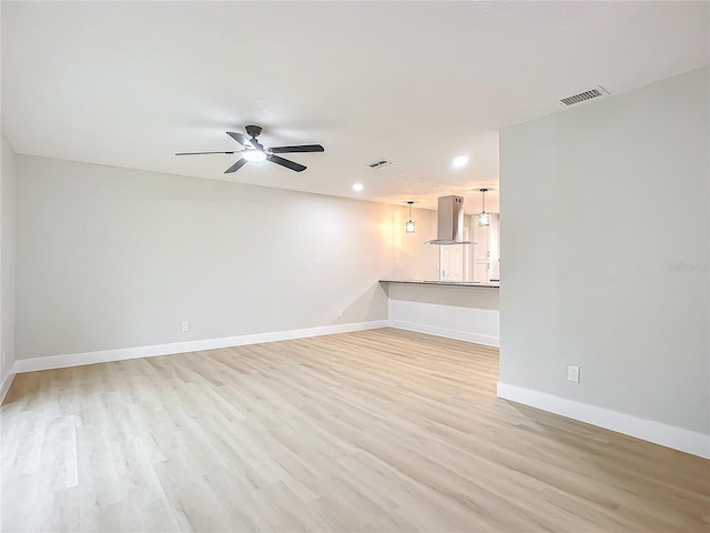 unfurnished living room featuring ceiling fan and light wood-type flooring