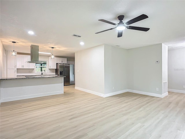 unfurnished living room with light hardwood / wood-style floors and ceiling fan