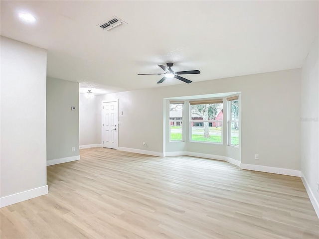 empty room with ceiling fan and light hardwood / wood-style floors