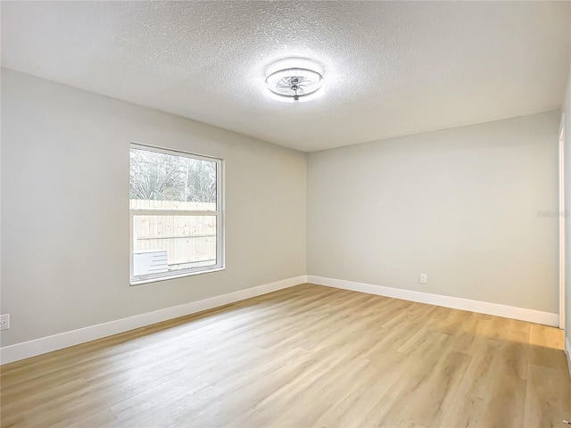 empty room featuring a textured ceiling and light wood-type flooring