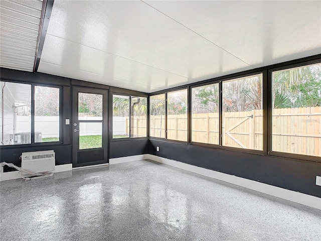 unfurnished sunroom with a wall mounted air conditioner