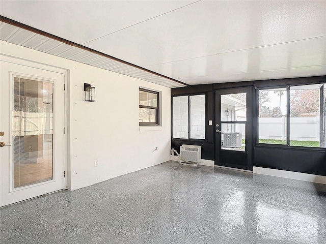 unfurnished sunroom featuring an AC wall unit