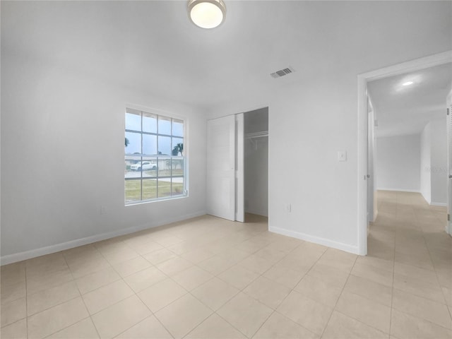 unfurnished bedroom featuring a closet and light tile patterned floors