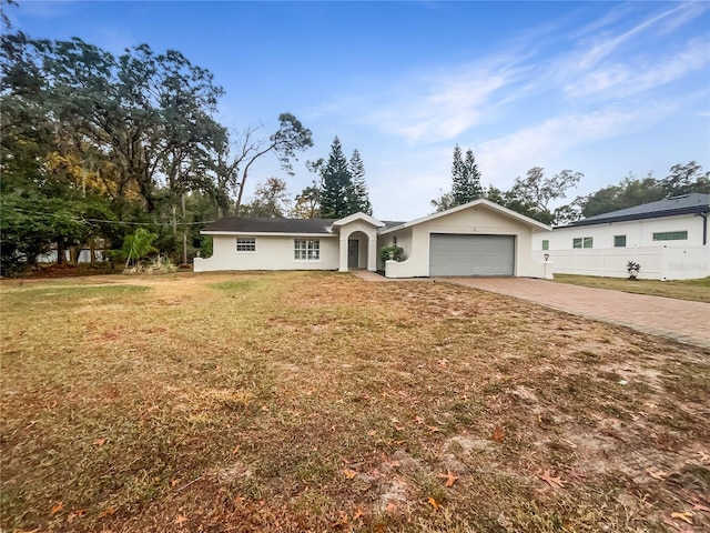 single story home featuring a garage and a front yard