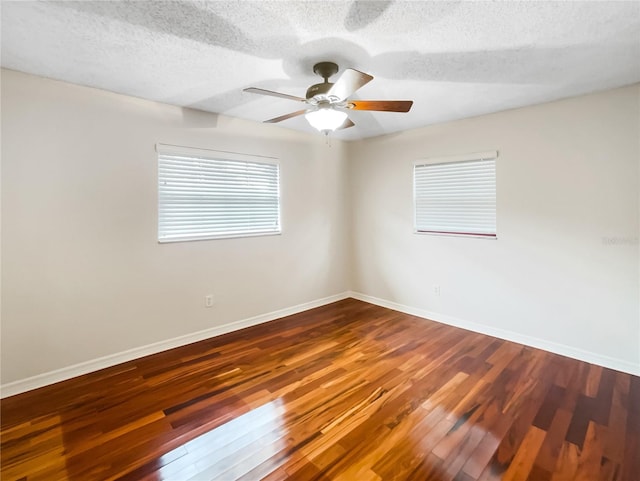 empty room featuring dark wood-type flooring, ceiling fan, and a textured ceiling