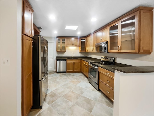 kitchen featuring sink, stainless steel appliances, and dark stone counters