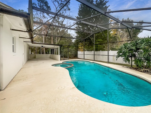 view of swimming pool with an in ground hot tub, glass enclosure, and a patio