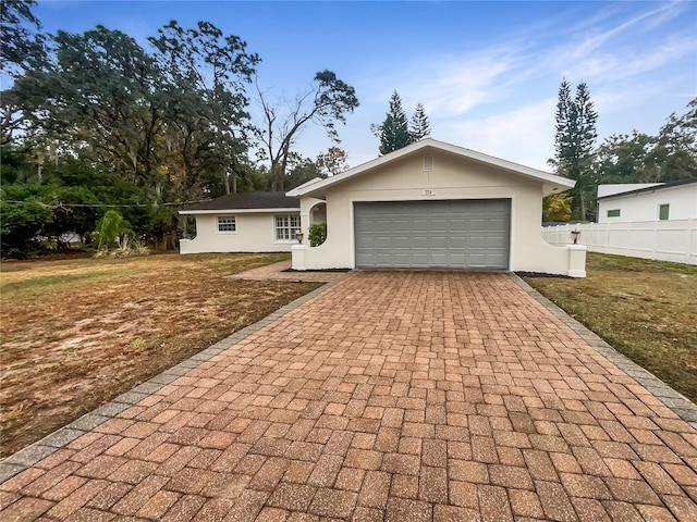 single story home with a garage and a front lawn