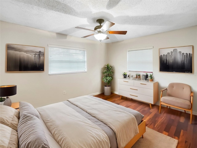 bedroom with ceiling fan, dark hardwood / wood-style flooring, and a textured ceiling