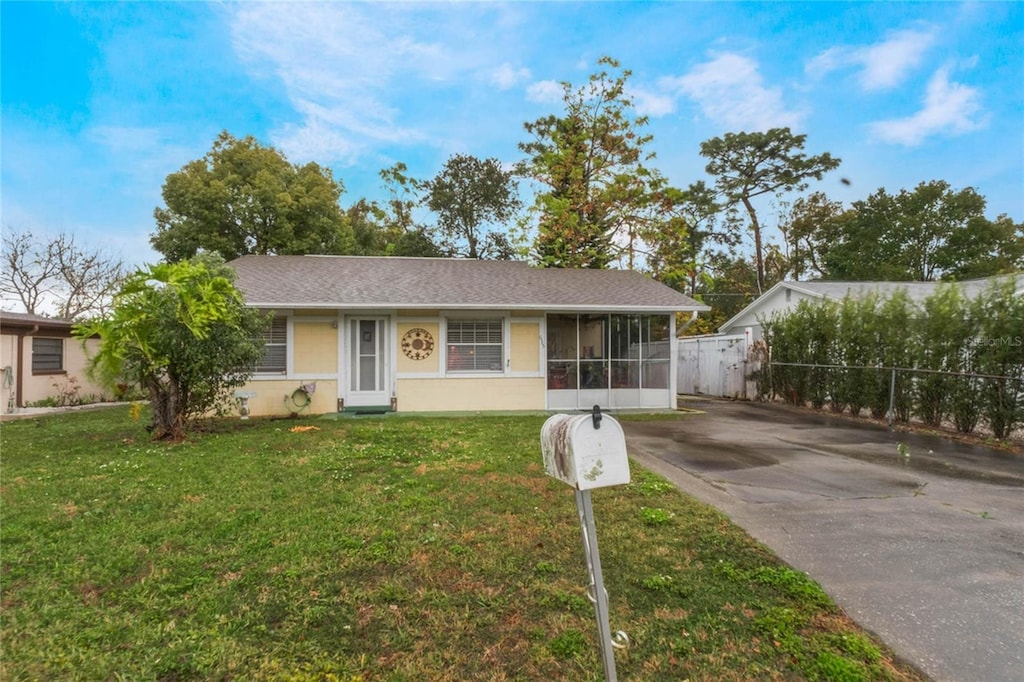 ranch-style home with a sunroom and a front yard