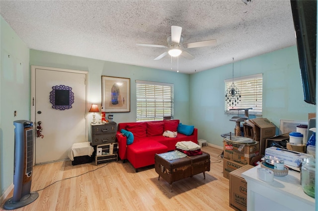 living room featuring ceiling fan, a textured ceiling, and light hardwood / wood-style flooring