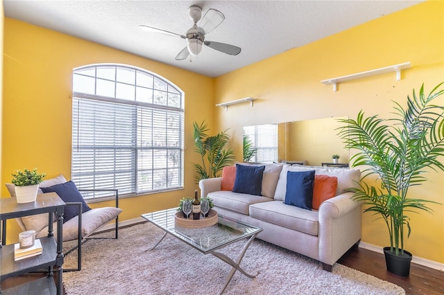 living room with hardwood / wood-style flooring, a textured ceiling, and ceiling fan