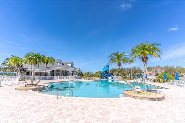 view of pool featuring a patio area, a playground, and a water slide