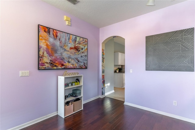 hall featuring dark wood-type flooring and a textured ceiling