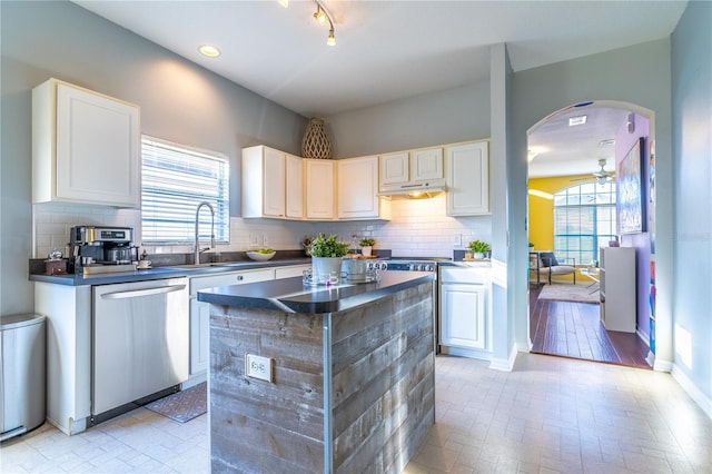 kitchen with sink, ceiling fan, white cabinets, decorative backsplash, and stainless steel dishwasher