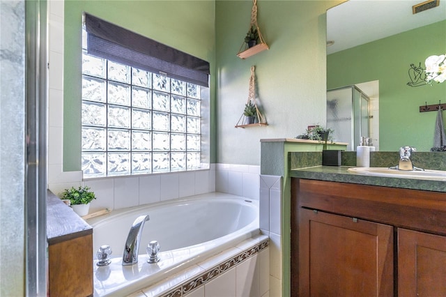 bathroom featuring vanity and separate shower and tub