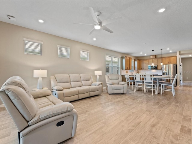 living room featuring ceiling fan and light wood-type flooring