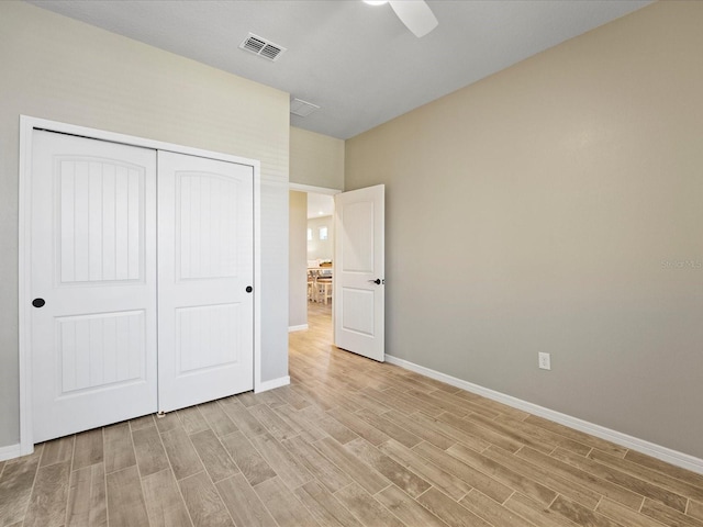 unfurnished bedroom featuring light hardwood / wood-style flooring, ceiling fan, and a closet