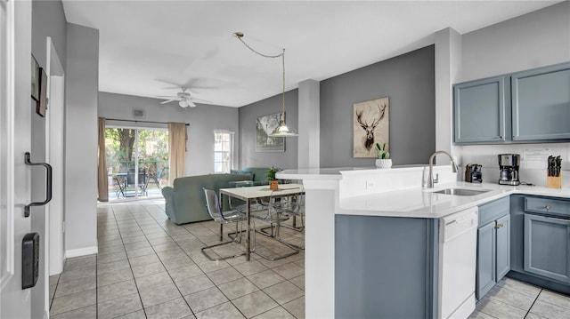 kitchen featuring white dishwasher, sink, light tile patterned floors, and kitchen peninsula