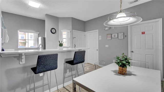 tiled dining room featuring a textured ceiling