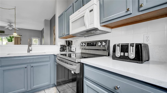 kitchen with sink, backsplash, stainless steel range with electric cooktop, and light tile patterned flooring