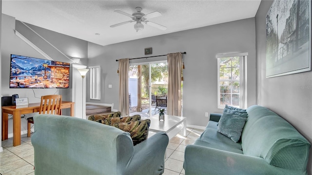 living room featuring ceiling fan, a textured ceiling, and light tile patterned floors