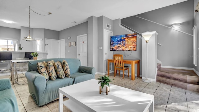 living room featuring sink and light tile patterned flooring