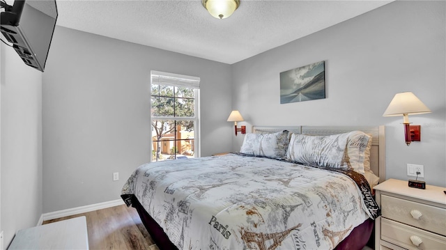 bedroom featuring hardwood / wood-style flooring and a textured ceiling