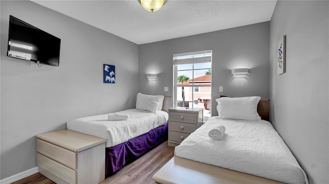 bedroom featuring light hardwood / wood-style floors and a textured ceiling