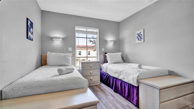 bedroom featuring light hardwood / wood-style floors and a textured ceiling