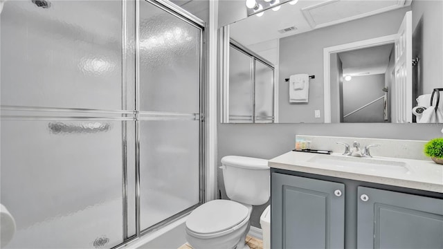 bathroom with vanity, toilet, and a shower with shower door