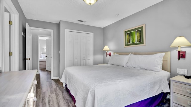 bedroom with hardwood / wood-style floors, a closet, and a textured ceiling