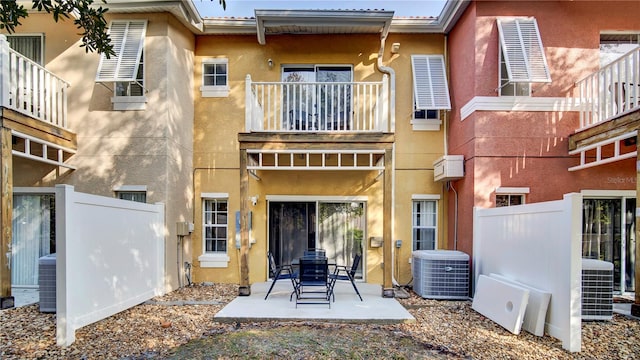 rear view of house with central AC and a patio