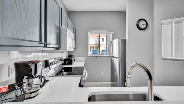 kitchen featuring appliances with stainless steel finishes, sink, and gray cabinetry