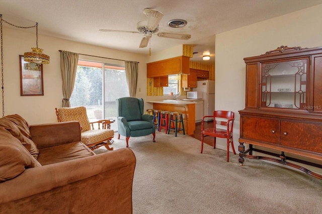 living room featuring sink, light carpet, a textured ceiling, and ceiling fan