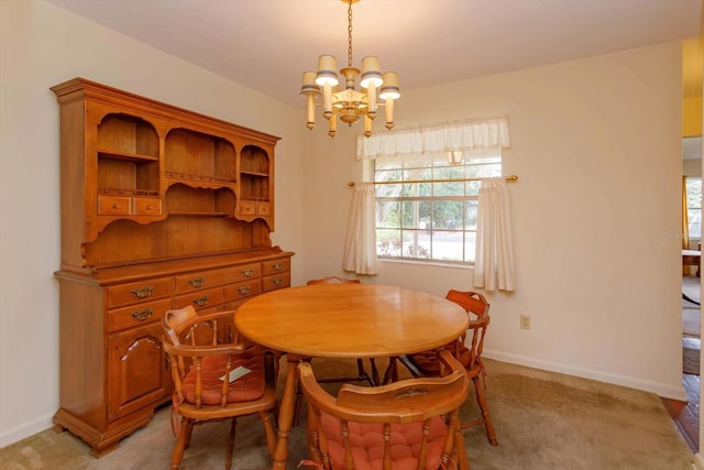 carpeted dining room with an inviting chandelier