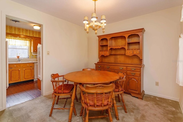 dining area featuring sink, light colored carpet, and an inviting chandelier