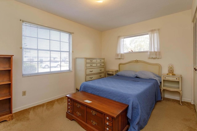 bedroom featuring multiple windows and light colored carpet