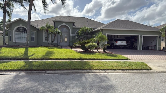 ranch-style house featuring a garage and a front lawn